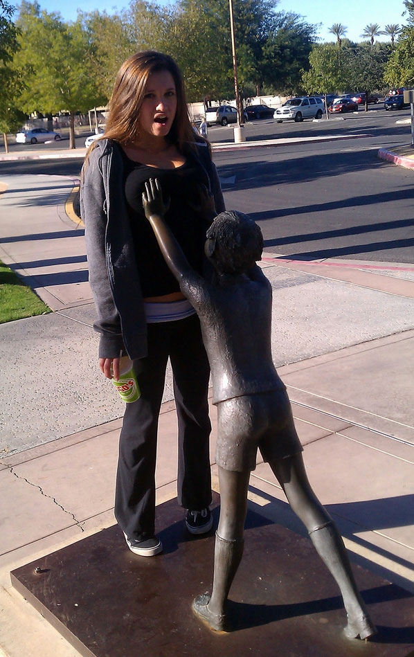 girl touch her brest to statue hand